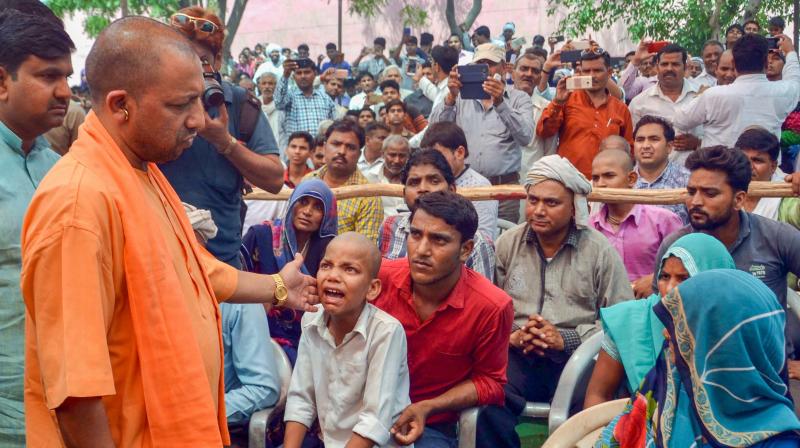 The CM, who reached Agra on Friday night cutting short his Karnataka poll campaign after the opposition targeted him for his absence from the state, met people injured in the dust storm. (Photo: PTI)