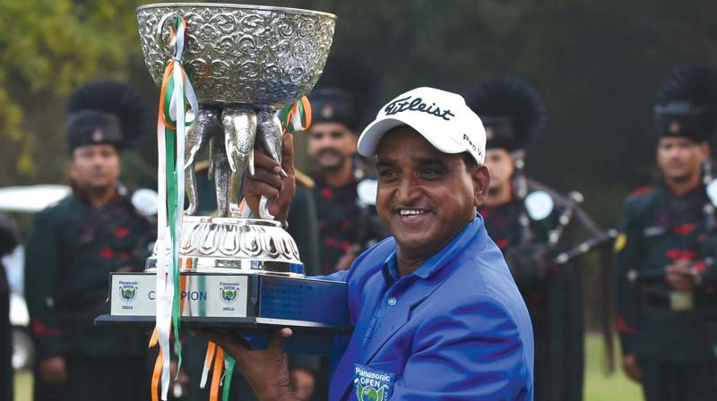 Mukesh Kumar poses with the trophy after winning the Panasonic Open India in New Delhi on Sunday. (Photo: AFP)