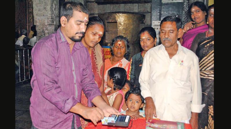 Devotees at the Tiruttani Murugan Temple giving their contribution through debit card. (Photo: DC)