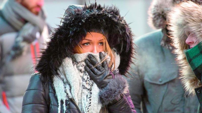 Pedestrians in New York swathe themselves in layers of wool as the mercury falls to near freezing temperatures on Friday.