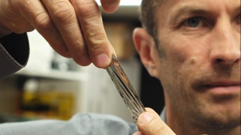 IBM scientist Mark Lantz holding a sample of the new high-density magnetic tape (Credit: IBM Research)