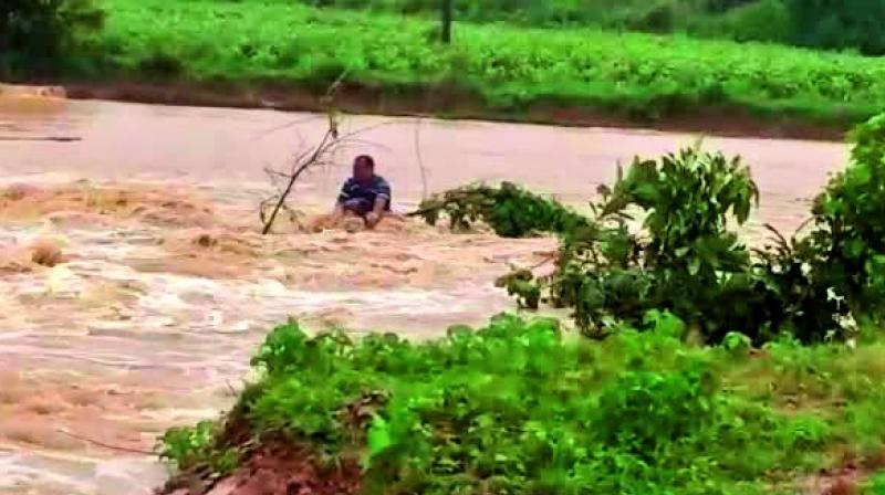 A police constable was trapped for a few hours in the flood-waters in Mulug mandal on Saturday. Villagers rescued him using a rope after the waters receded.   	(Photo:DC)
