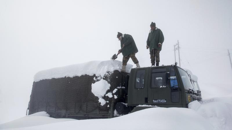 Army soldiers clear snow from their stranded vehicle near a base camp in Gulmarg, Jammu and Kashmir. (Photo: AP)