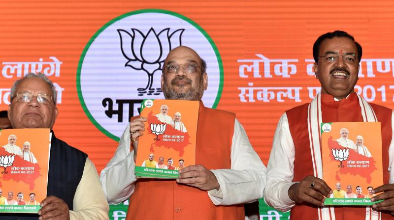 BJP President Amit Shah with UP BJP chief Keshav Prasad Maurya releasing party manifesto for the upcoming Uttar Pradesh assembly elections in Lucknow. (Photo: PTI)