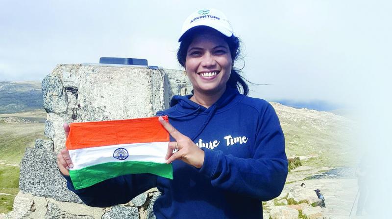 Radhika G.R. stands tall with the Indian flag after climbing one of the 10 Australian peaks.