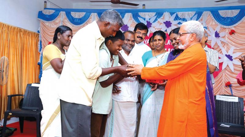 Swami Viviktananda Saraswathi handing over the keys of the house to the family members of Sabu.