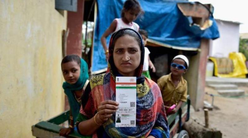 A woman shows her Aadhaar card that has been made compulsory for a number of govt schemes. (Photo: PTI)