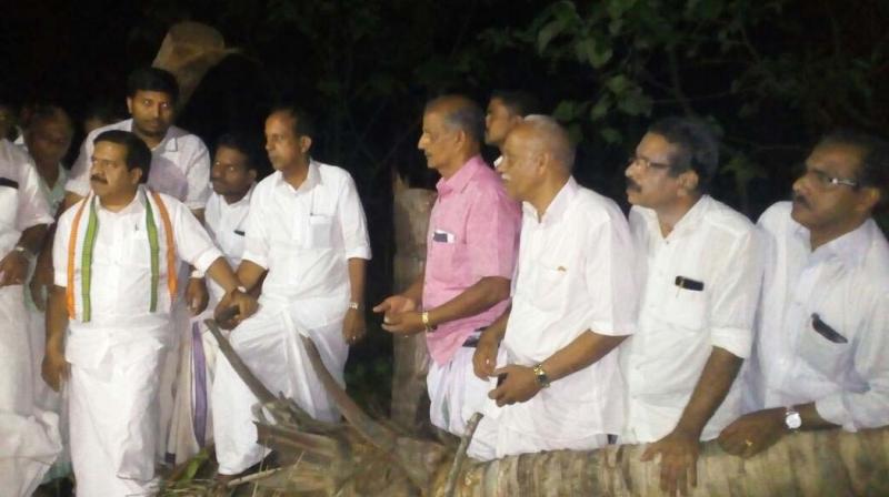 Opposition leader Ramesh Chennithala visiting the plot of Vinodan in Kuttiady, where 41 coconut trees were felled using machine.