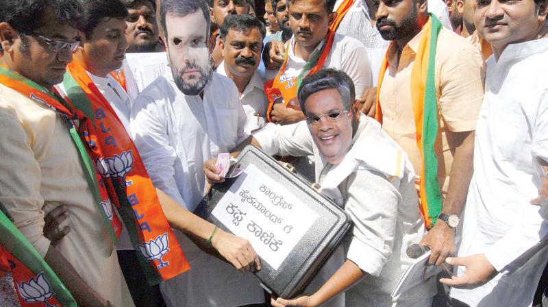 BJP Yuva Morcha members protest against Chief Minister Siddaramaiah over his alleged payoffs to Congress high Command, in Bengaluru on Friday. (Photo: DC)