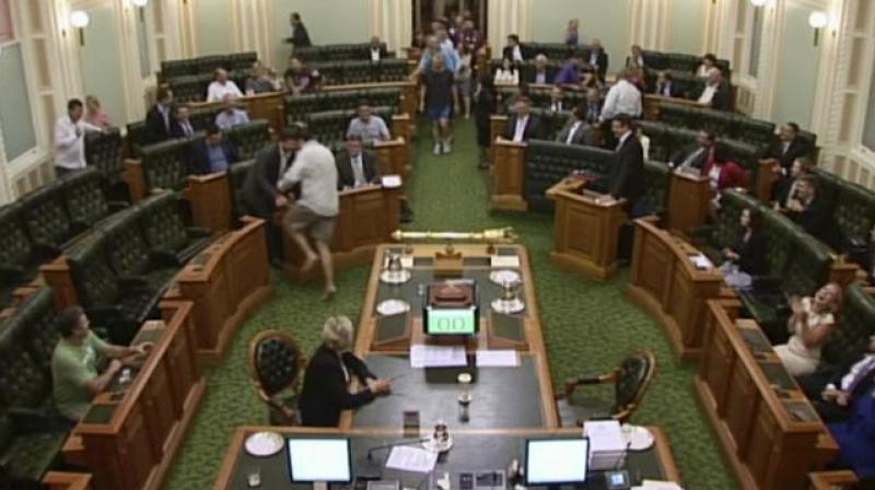 A video grab of lawmakers running onto the chamber floor in bare feet and shorts. (Photo: AP)