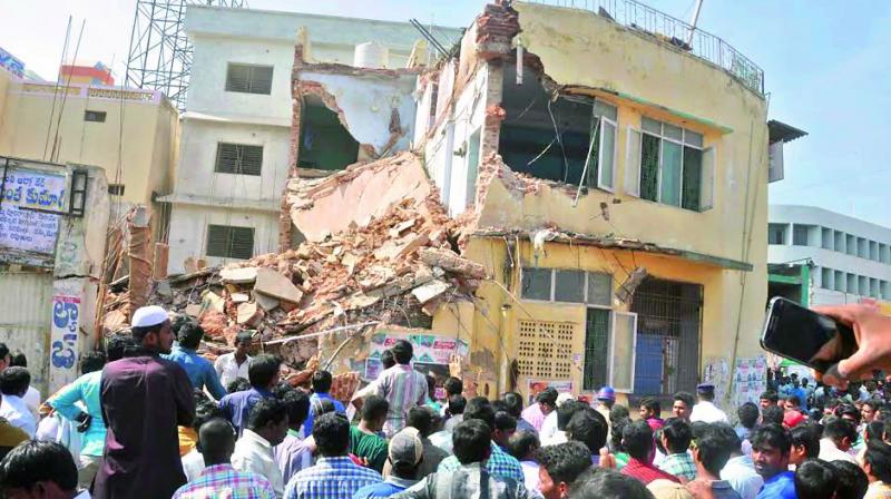 People look at the partly collapsed Sujatha hotel building in Kadapa on Friday. (Photo: DC)