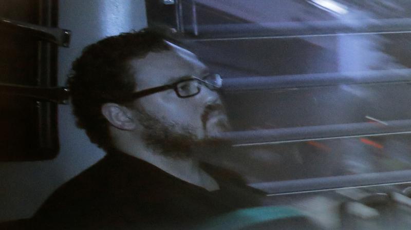 Rurik Jutting, a British banker, sitting in a prison bus arrives at a court in Hong Kong.