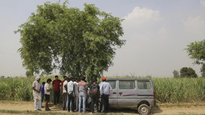 Villagers gather near a crime scene in a field near Jewar. (Photo: AP)