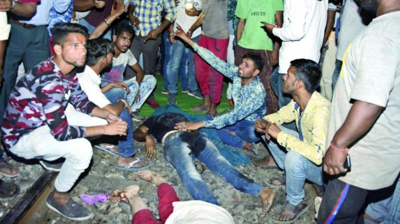 An angry crowd shout slogans as they sit by bodies of victims of the train accident in Amritsar on Friday. (Photo: AP)
