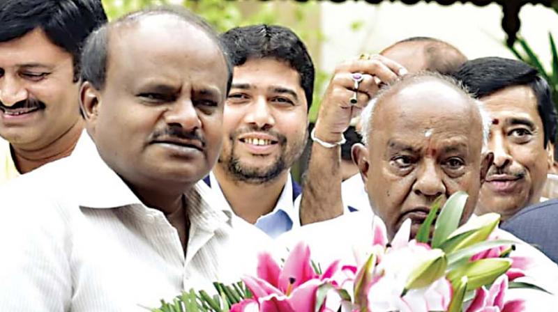 Chief Minister H.D. Kumaraswamy with his father and JD(S) national president H.D. Deve Gowda