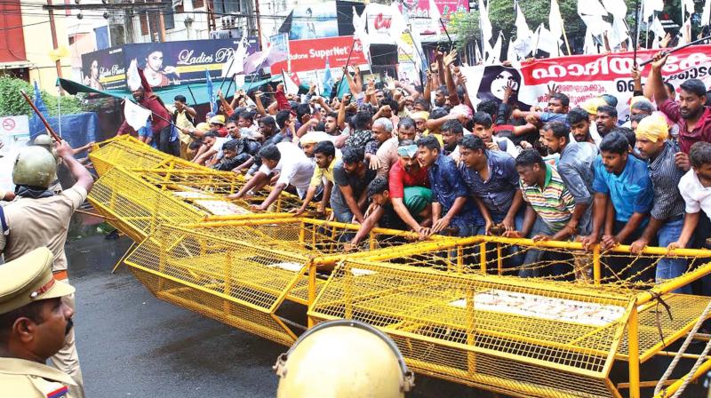 Muslim co-ordination committee supporters try to overcome the police barricades after taking out a march to Kerala High Court in Kochi on Monday.  (Photo: DC)