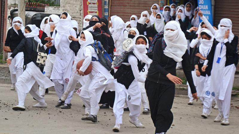 Girl students pelt stones at security personnel during clashes in the vicinity of Lal Chowk in Srinagar on Monday. (Photo: PTI)