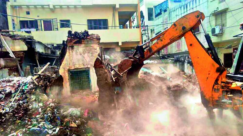 In a recent drive, the GHMC razes a dilapidated property in the city.  	(Photo:DC)