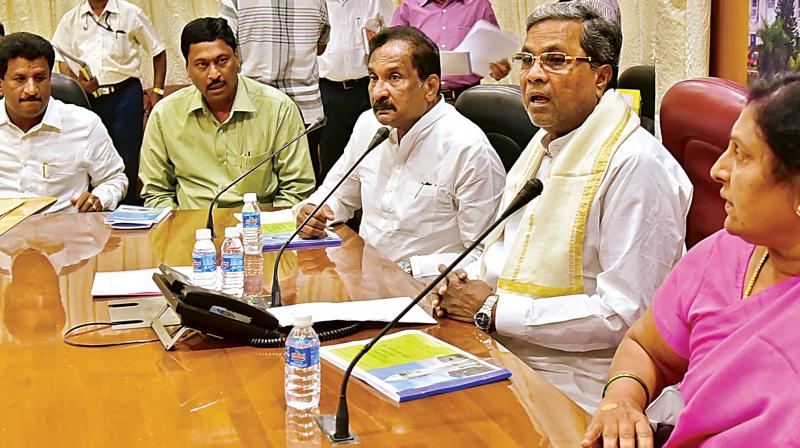 Chief Minister Siddaramaiah, with Bengaluru Development Minister K.J. George and Mayor Padmavathi, addresses BBMP officials during a review meeting at his home office Krishna, in Bengaluru on Wednesday. (Photo: DC)