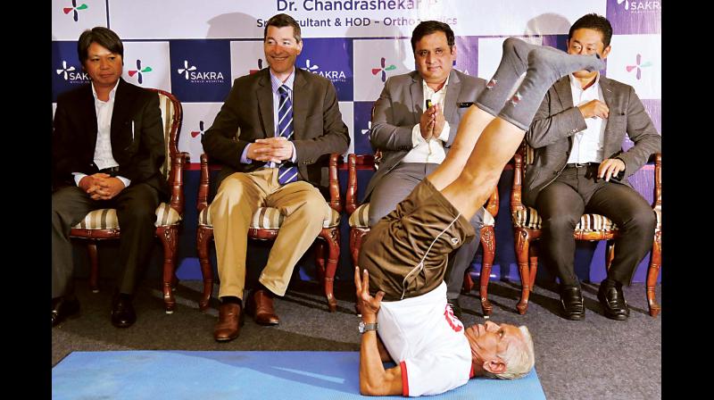 SK Srinivasan (83), who underwent both knee replacement surgeries by Dr Chandrashekar P from Sakra World Hospital performs Yoga in Bengaluru on Wednesday during a press conference. (Photo: KPN)