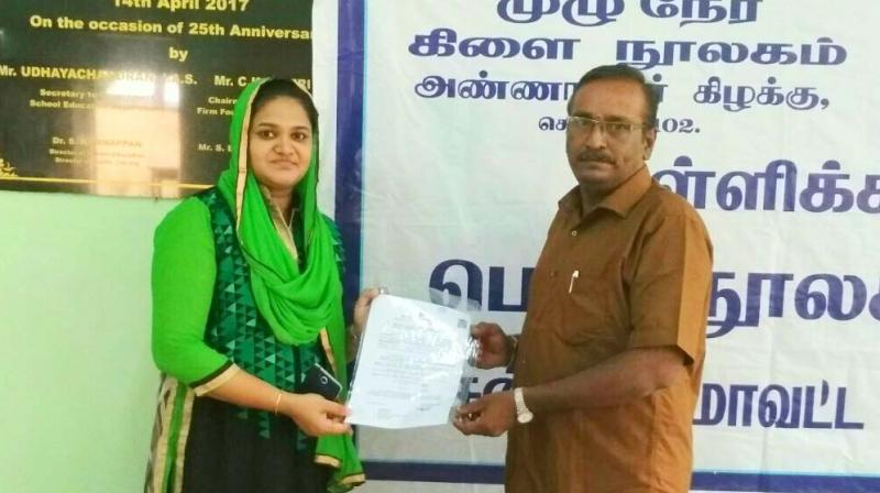 Shabana Anjum is being felicitated for successfully clearing the TNPSC Group 1 exam by librarian  S. Ranganathan of Anna Nagar (East) library. (Photo: DC)
