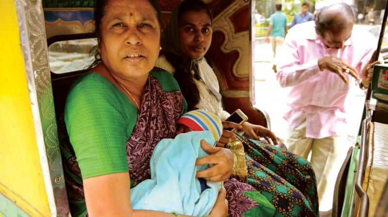 A woman takes her daughter and grandchild to a hospital in an autorickshaw in Bengaluru on Thursday. (Photo: DC)