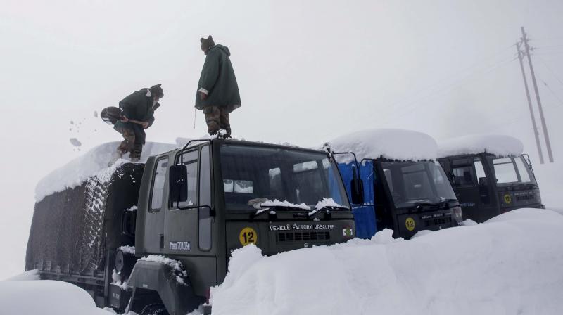 Indian Army soldiers clear snow from their stranded vehicles near a base camp in Gulmarg. (Photo: PTI)