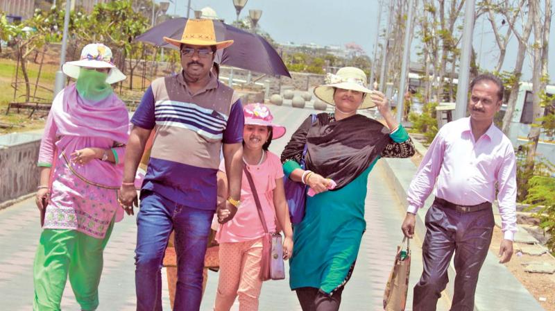 People use hats to beat the scorching heat at Marina on Wednesday (Photo: DC)