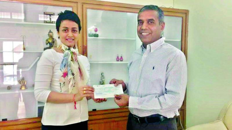 Inspiring: Namrata handing over a cheque of Rs 30 lakh to the Ranga Reddy District collector Raghunandan Rao.