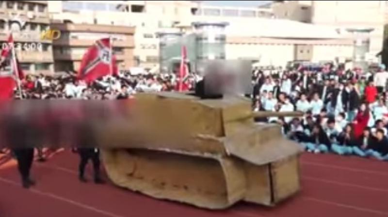 A teacher also joined in the procession and was seen giving a Nazi salute as he stood inside a tank made of paper cartons, according to local media. (Photo: Videograb)