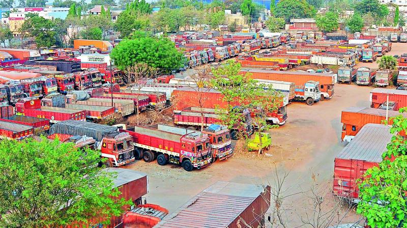 Hundreds of trucks parked at Vanasthalipuram on the fourth day of the strike against excessive tolls on Sunday.