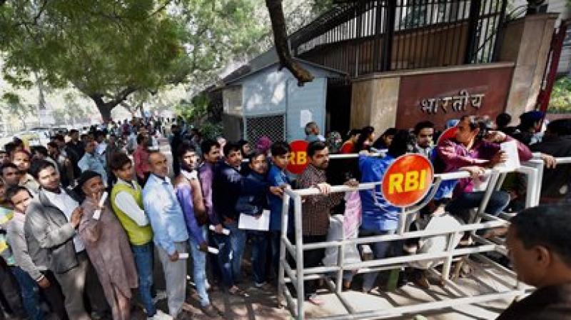 People stand in queue to deposit or exchange their old currency notes outside RBI bank in New Delhi. (Photo: PTI)