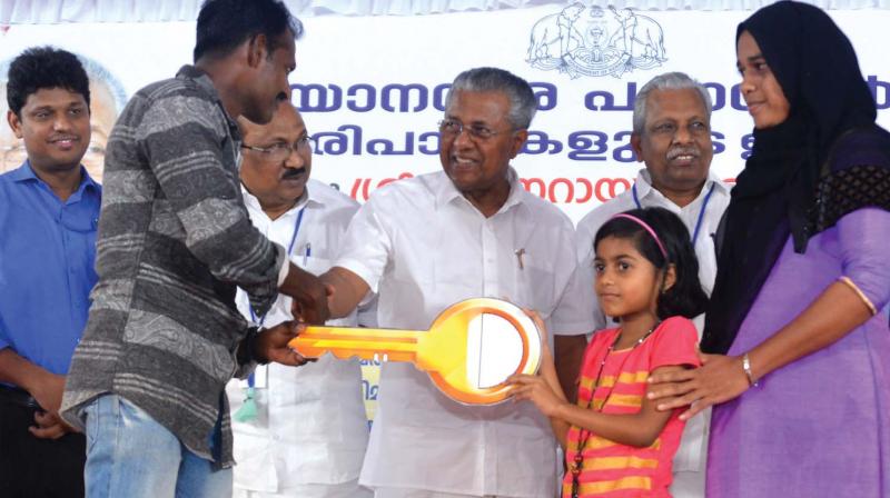 Chief Minister Pinarayi Vijayan distributes the key of one of the 75 houses rebuilt post floods in Ernakulam district at a function in Chendamangalam on Sunday.
