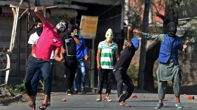Protesters throw stones at Police and CRPF personnel during a protest after Friday prayers in Srinagar. (Photo: PTI)