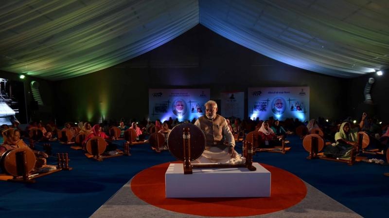 Prime Minister Narendra Modi works at a charkha at a ceremony to distribute charkhas to women before the National MSME Awards at Punjab Agricultural University in Ludhiana. (Photo: PTI)