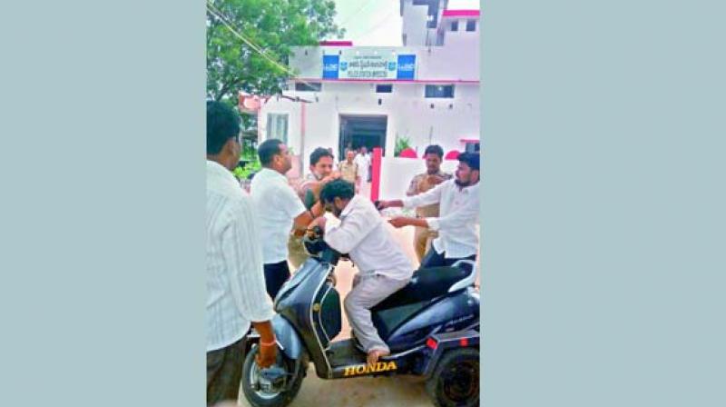 A CCTV grab of Mirdoddi SI Shiva assaulting physically challenged Mogulla Ilaiah outside the police station. 	(Photo: DC)