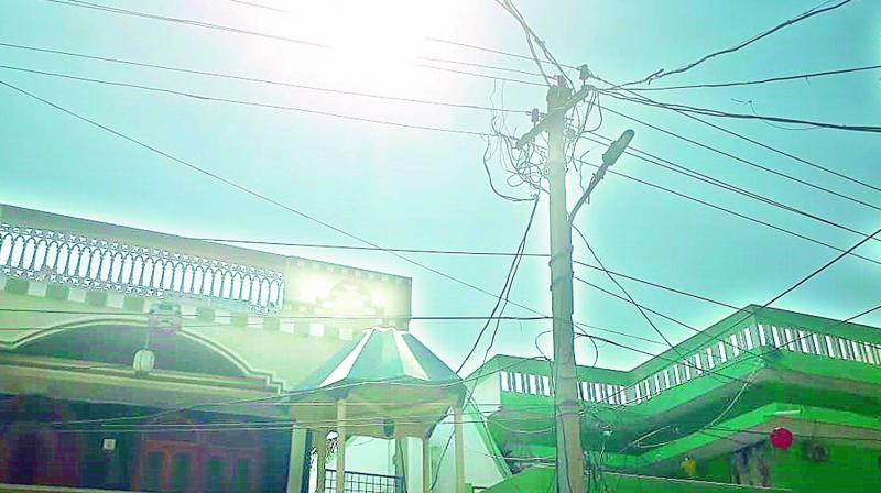 Electricity wires pass close to the terrace of a house in a Malkajgiri.