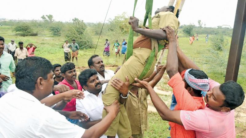 Health Minister  C. Vijayabaskar  rescues a worker engaged in restoration work of electricity poles in Kalamavur  village in Pudukkottai district. (Image DC)