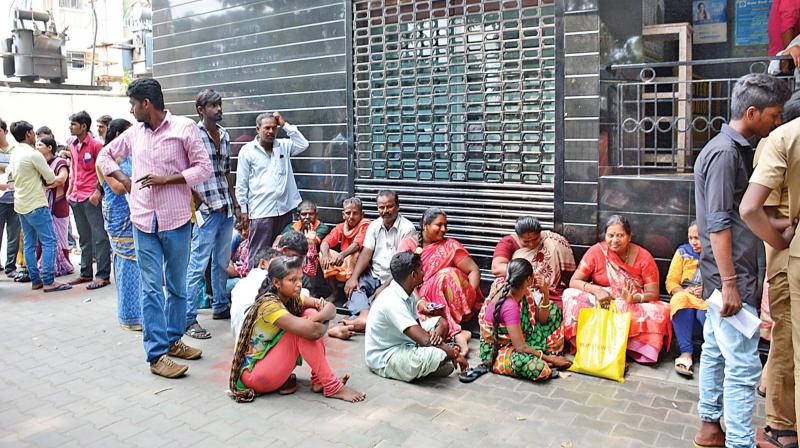 People waiting outside an ATM in the city on Thursday. (Photo: DC)