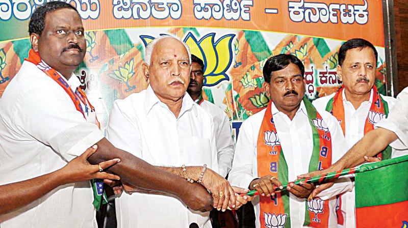 BJP state president B.S. Yeddyurappa welcomes Dalit leader Anjan Kumar and  others who joined the party in Bengaluru on Tuesday