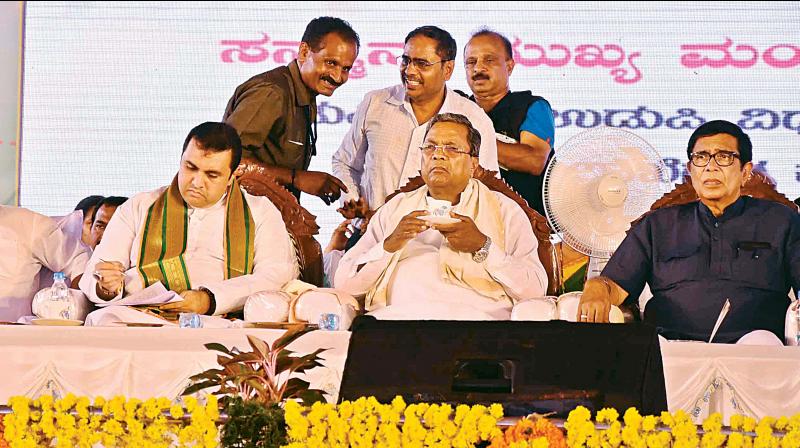 Minister for Fisheries Pramod Madhwaraj, CM Siddaramaiah and Congress MP Oscar Fernandes at a function in Brahmavara in Udupi district on Monday. (Photo: DC)