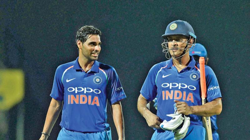 Bhuvneshwar Kumar and M.S. Dhoni. (Photo: PTI)