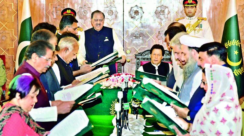Pakistans President Mamnoon Hussain, centre left, administrates oath of office to federal ministers while Prime Minister Imran Khan, centre right, looks on during a ceremony at a presidential palace in Islamabad. (Photo: AP)