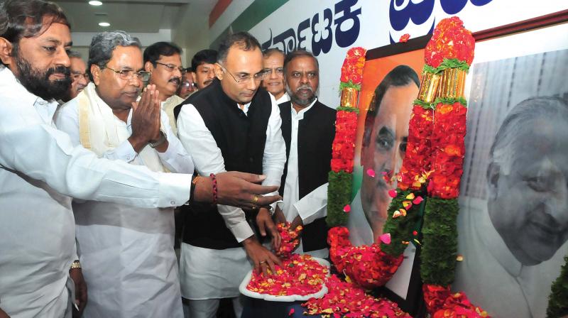 KPCC chief Dinesh Gundurao, former CM Siddaramaiah and KPCC working president Eshwar Khandre offer floral tributes to Rajiv Gandhi and Devaraj Urs at a function to mark their birth anniversaries in Bengaluru on Monday.