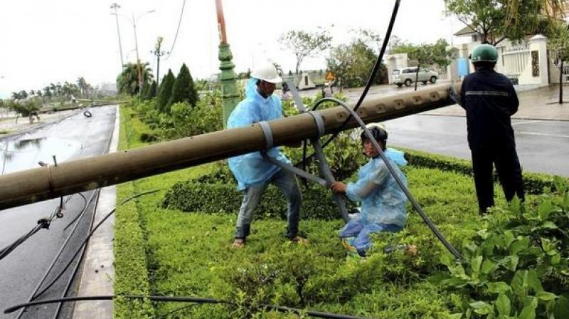 Workers repair a fallen electricity pole in the central province of Phu Yen, Vietnam on Saturday after Typhoon Damrey slammed the countrys south-central coast. (Photo: AP)