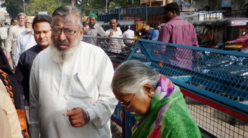 Senior citizens queue up outside a bank to exchange currency