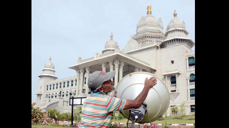 A worker fixing the floodlight on the Suvarna Vidhana Soudha premises in Belagavi where the winter session of the State Legislature will be held from Monday (Photo: KPN)
