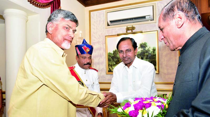 TS Chief Minister K. Chandrasekhar Rao greets his AP counterpart N. Chandrababu Naidu as Governor E.S.L Narasimhan looks on, at the At Home hosted by the Governor at Raj Bhavan, in Hyderabad on Thursday.