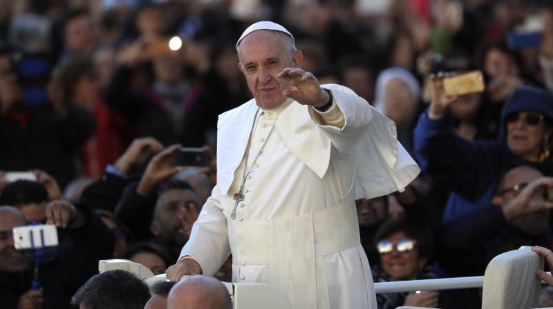 Pope Francis waves as he is driven across the crowd ahead of his weekly general audience, in St. Peters Square, at the Vatican. (Photo: AP)