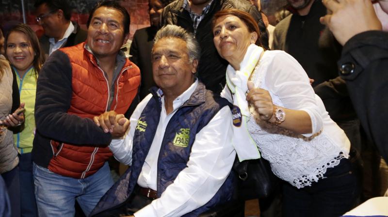 Lenin Moreno, presidential candidate for the ruling party Alliance PAIS, center, poses for a photo with supporters after a news conference in Quito, Ecuador, Monday. (Photo: AP)